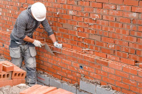 Building Worker Laying Bricks for Building a wall.