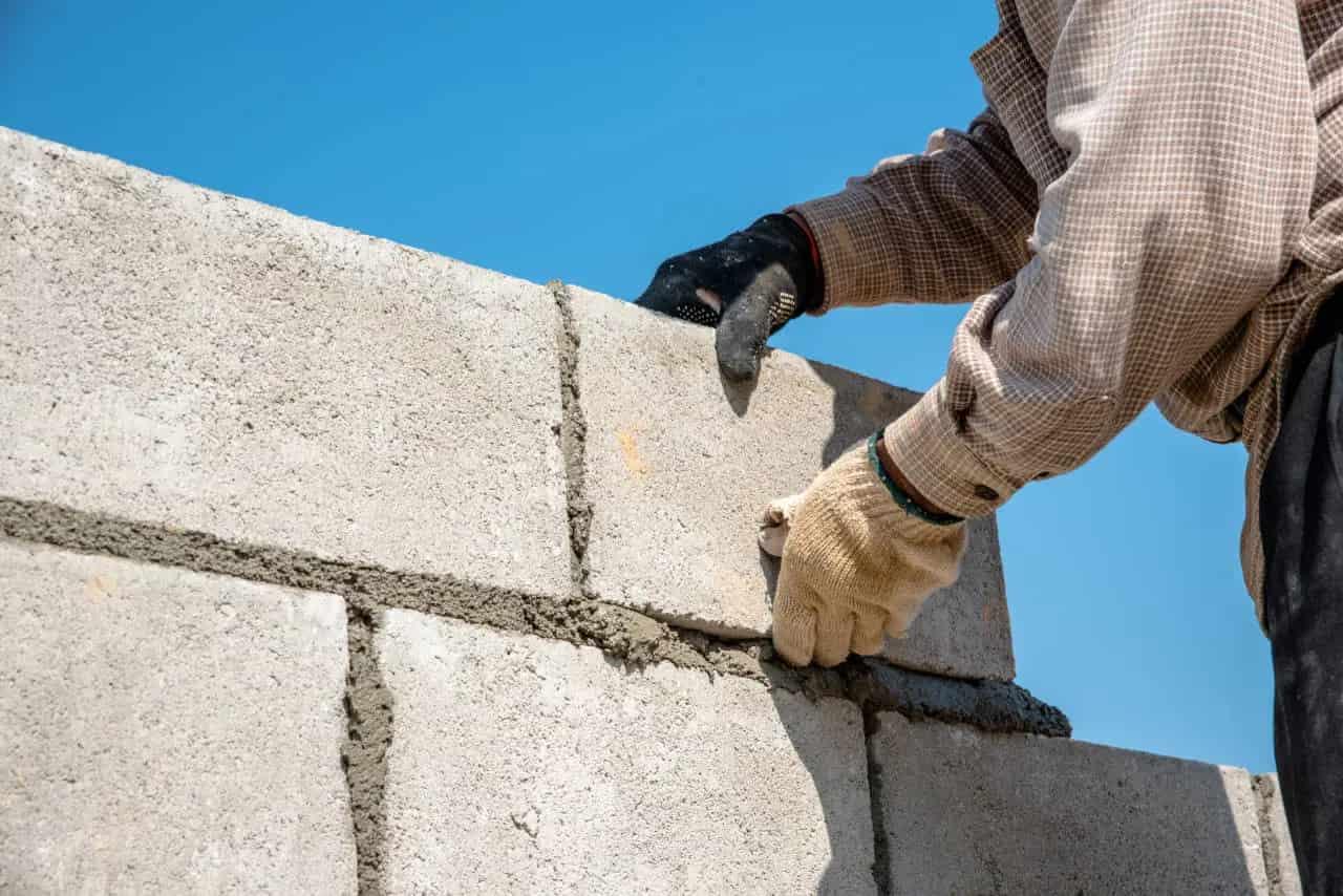 Building Worker Laying Bricks for Building a wall.